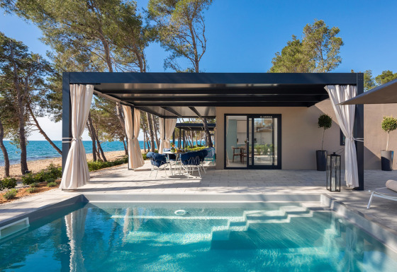 Chalet Amber Sea Luxury Holiday Home Pool con piscina privada, terraza sombreada y vistas al mar.