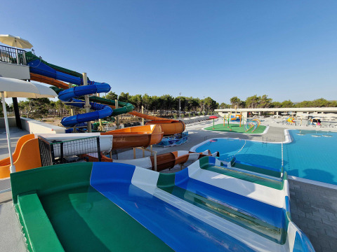 Parque acuático con toboganes de colores y piscina en Aminess Style Camping Avalona Resort, Croacia.