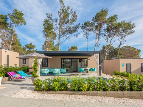 Modern holiday home at Aminess Style Camping Avalona Resort in Zadar, Croatia, with patio and sun loungers.