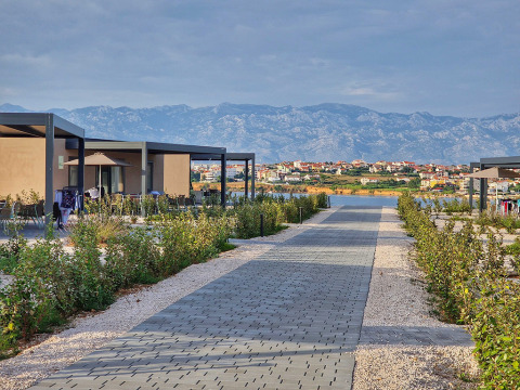 Moderne ferieboliger i Aminess Style Camping Avalona Resort med udsigt til bjerge og landsby i Kroatien.