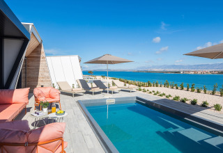 Moderne Poolterrasse mit Sonnenliegen, Sonnenschirmen und Meerblick im Aminess Style Camping Avalona Resort, Kroatien.
