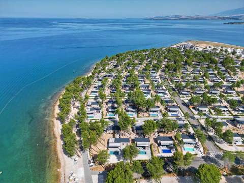 Vista aérea del Aminess Style Camping Avalona Resort junto al mar en Zadar, Croacia, rodeado de árboles verdes.