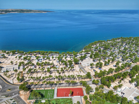 Luchtzicht op Aminess Style Camping Avalona Resort in Kroatië met zee, bomen en sportfaciliteiten in beeld.
