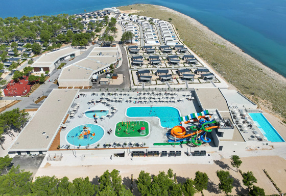 Vista aérea de Aminess Style Camping Avalona Resort en Zadar, Croacia, con piscinas, toboganes y cabañas junto al mar.