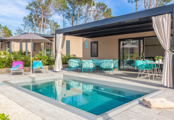 Außenbereich der Family Luxury Holiday Home Pool mit privatem Pool, Lounge-Möbeln und Sonnenschirm.