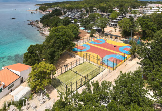 Villaggio vacanze con campi sportivi colorati vicino al mare turchese all’Aminess Style Camping Atea Resort, Croazia.
