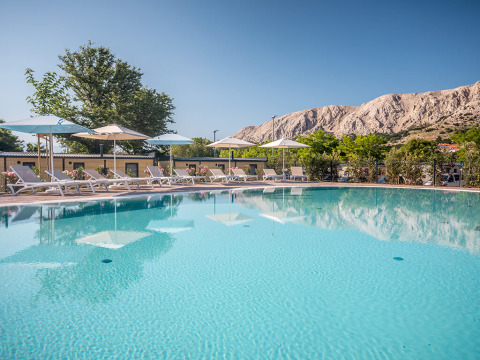Außenpool mit Liegestühlen und Sonnenschirmen im Valamar Camping Baška, Primorje-Gorski Kotar, Kroatien.