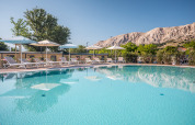 Piscina all'aperto con lettini e ombrelloni al Valamar Camping Baška, Primorje-Gorski Kotar, Croazia.