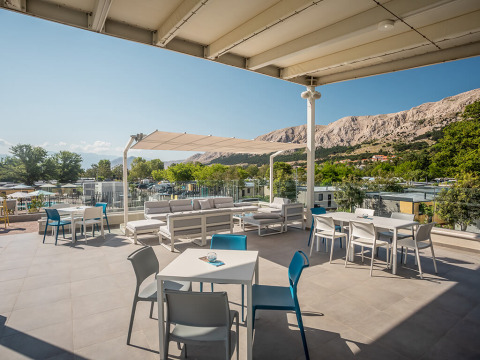 Terraza al aire libre en Valamar Camping Baška con vistas a montañas en Primorje-Gorski Kotar, Croacia.
