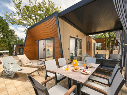 Hébergement moderne avec terrasse, transats et petit-déjeuner extérieur à Aminess Style Camping Atea Resort, Croatie.