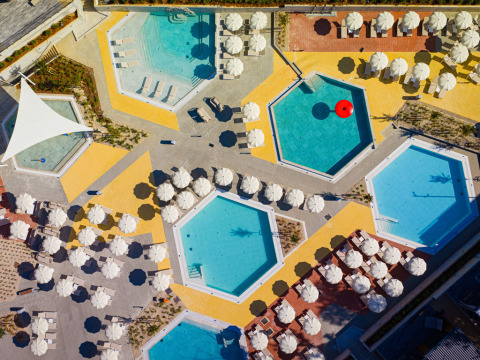 Aerial view of pools, sun loungers and umbrellas at Aminess Style Camping Atea Resort in Croatia.