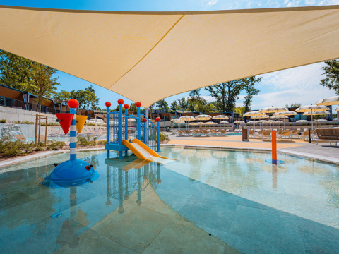 Aire de jeux aquatique pour enfants avec toboggan et transats à Aminess Style Camping Atea Resort, Croatie.