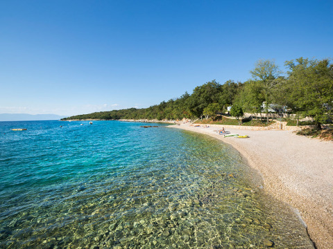 Kiezelstrand en helderblauw water bij Aminess Style Camping Atea Resort in Primorje-Gorski Kotar, Kroatië.