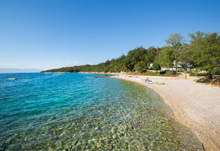 Kiezelstrand en helderblauw water bij Aminess Style Camping Atea Resort in Primorje-Gorski Kotar, Kroatië.