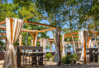 Außenterrasse mit Holzpergolen und Vorhängen im Aminess Style Camping Atea Resort, Kroatien