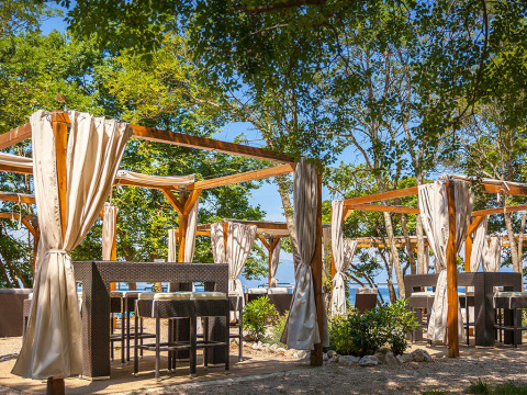 Buitenterras met houten pergola's en gordijnen bij Aminess Style Camping Atea Resort, Kroatië