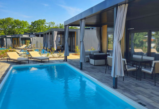 Private swimming pool, lounge chairs, and shaded patio in a stylish holiday resort at Aminess Style Camping Atea Resort.