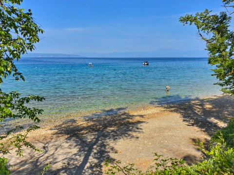 Uitzicht op strand en helderblauw water bij Aminess Style Camping Atea Resort, Primorje-Gorski Kotar, Kroatië.