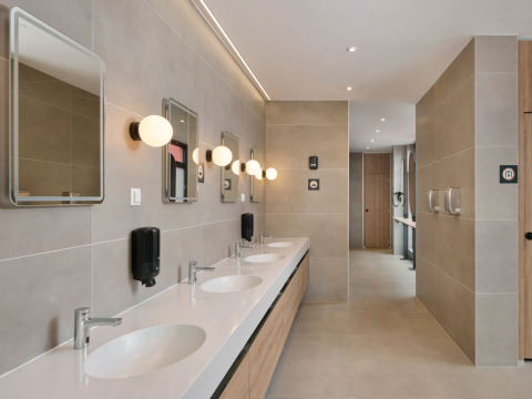 Modernes Gemeinschaftsbad mit mehreren Waschbecken, Spiegeln und Wandlampen im Aminess Style Camping Atea Resort, Kroatien.