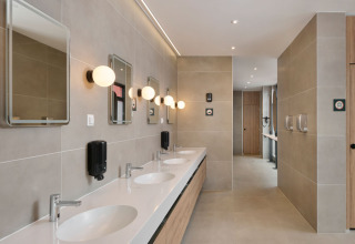 Salle de bains commune moderne avec plusieurs lavabos, miroirs et éclairages au Aminess Style Camping Atea Resort, Croatie.