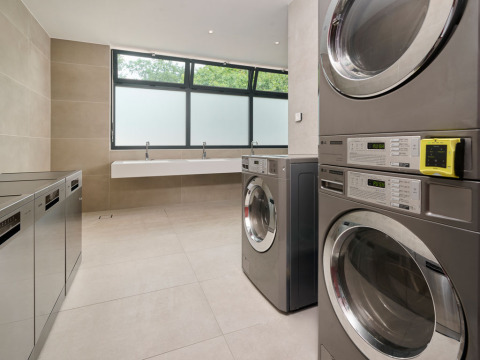 Modern laundry room with several washers and dryers at Aminess Style Camping Atea Resort in Croatia.