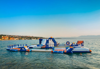 Parco acquatico gonfiabile all'Aminess Style Camping Atea Resort in Croazia con bambini che giocano in mare.