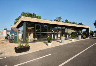 Moderne Empfangsgebäude mit großen Fenstern und Blumentöpfen im Aminess Style Camping Atea Resort in Kroatien.