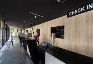 Reception di Aminess Style Camping Atea Resort con banchi moderni e personale in Croazia.