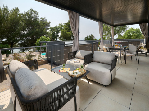 Moderne buitenterras met comfortabele loungefauteuils bij Amber Luxury Holiday Home op Aminess Style Camping Atea Resort, Kroatië.