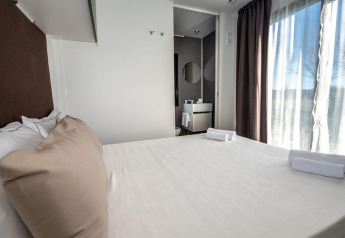 Moderne soveværelse i Camping Home Green på Camping Arena Grand Kažela i Kroatien med stor seng og lysindfald.