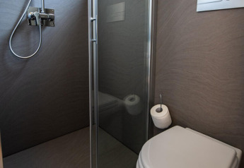 Moderne camping toiletrum med bruser, toilet og vindue i Camping Home Green, Arena Grand Kažela, Kroatien.