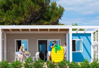 Familie nyder tid foran en chalet på Camping Home Next, Camping Arena Grand Kažela, Kroatien.