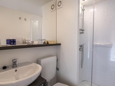 Moderne badkamer in een glamping safaritent met wastafel, toilet en douche op Camping Arena Stoja in Kroatië.