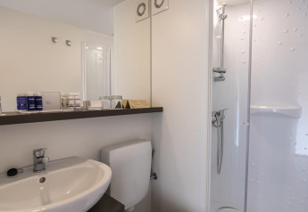 Baño moderno en una tienda glamping safari con lavabo, inodoro y ducha en Camping Arena Stoja, Croacia.