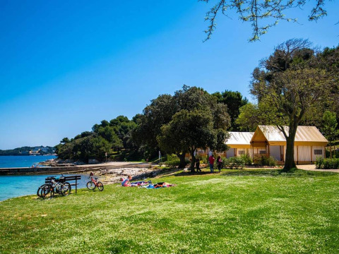 Zweizimmer-Glamping-Safari-Loftzelt im Camping Arena Stoja, Kroatien, am Meer mit Fahrrädern sichtbar.