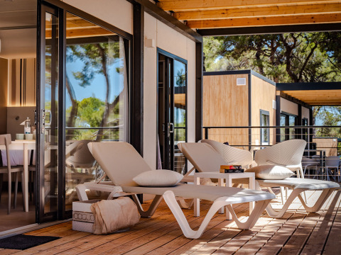 Moderne Terrasse mit Liegestühlen und Lounge-Möbeln in der Camping Villa im Camping Arena Stoja, Kroatien.