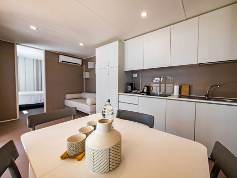 Moderne Lodge mit Küche, Essbereich und Sofa in der Camping Villa auf Camping Arena Stoja, Kroatien.