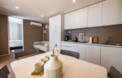 Modern lodge kitchen, dining table, and sofa area inside Camping Villa at Camping Arena Stoja, Croatia.