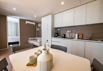 Cucina moderna, tavolo da pranzo e soggiorno della lodge Camping Villa presso Camping Arena Stoja, Croazia.