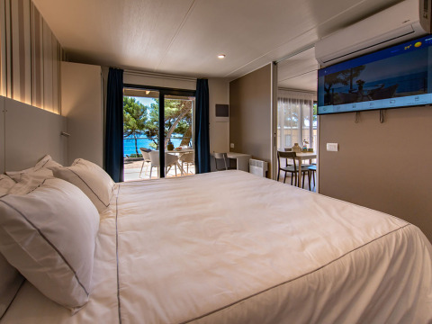 Modernes Lodge-Zimmer mit Meerblick, Doppelbett und Terrasse im Camping Villa bei Camping Arena Stoja, Kroatien.