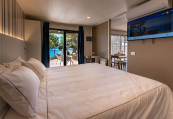 Dormitorio contemporáneo con vista al mar y terraza en Camping Villa de Camping Arena Stoja, Croacia.