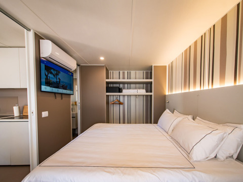 Camera moderna nella Camping Villa del Camping Arena Stoja in Croazia, con letto matrimoniale e TV a parete.