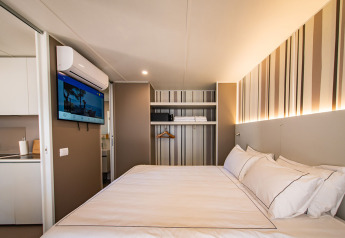 Camera moderna nella Camping Villa del Camping Arena Stoja in Croazia, con letto matrimoniale e TV a parete.