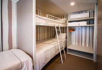 Camera compatta moderna con letto a castello e singolo presso Camping Villa al Camping Arena Stoja, Croazia.