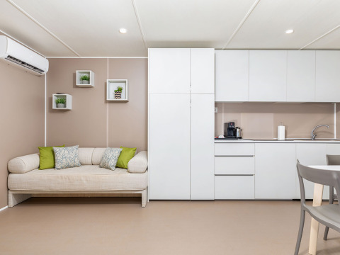 Interno lodge moderno con divano, cucina e arredo minimalista al Camping Arena Stoja, Croazia.