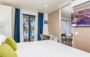 Modern lodge room with sea view, cozy bed, and stylish decor at Camping Villa Sea View, Arena Stoja, Croatia.