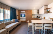 Modern living room and kitchen at Deluxe Camping Villa, Camping Arena Stoja, Croatia, with sofa and dining table.