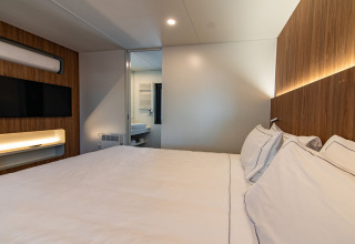 Schlafzimmer der Deluxe Camping Villa im Camping Arena Stoja, Kroatien mit Doppelbett und modernem Design.