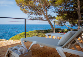 Afslappende terrasse med liggestole, havudsigt og træer på Deluxe Camping Villa Sea View, Camping Arena Stoja.