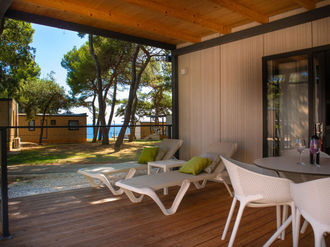 Terrasse extérieure avec transats et vue sur la mer à la Deluxe Camping Villa Sea View, Camping Arena Stoja, Croatie.